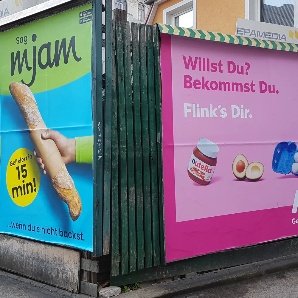 Zwei Plakatwände mit Werbung für unterschiedliche Delivery-Dienste